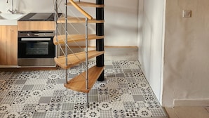 Een moderne keuken met een spiltrap, een spoelbak en een vloer met een patroon.