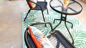 A patio with a table and chairs, a small garden, and a building entrance. - Lush 5-Bed Home @ Newcastle upon Tyne 
Central | Free parking | Bus @ door step (Newcastle upon Tyne)