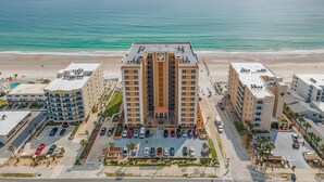 A high-rise hotel with a beach view, parking, and a pool area. - Sanibel 601 (Daytona Beach Shores)
