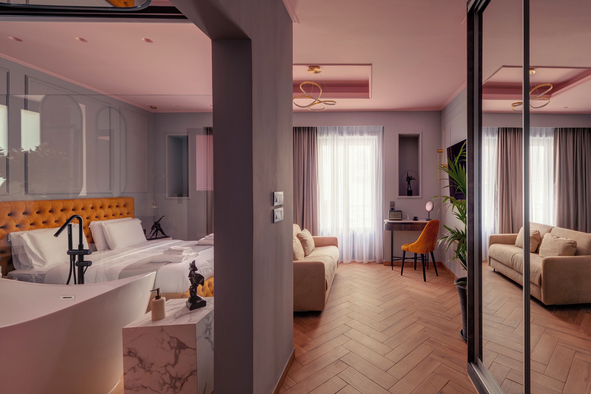 Una habitación de hotel moderna con una cama grande, un escritorio, un sofá y un comedor.