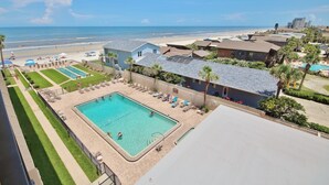 A resort with a swimming pool, beach view, and multiple buildings.