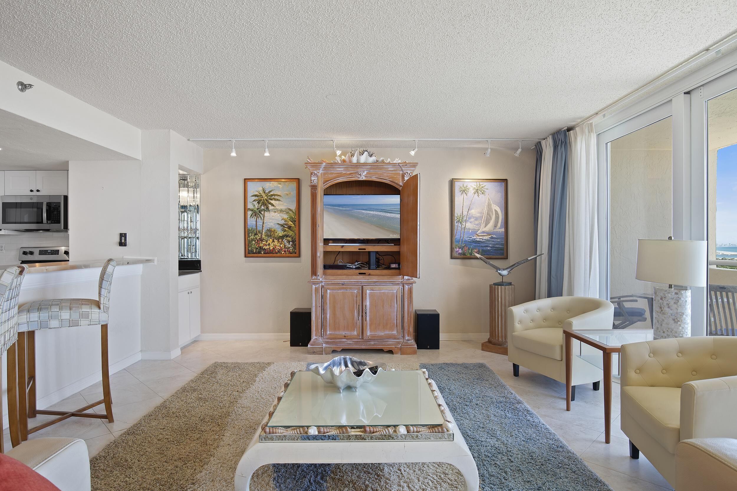 A modern living room with a flat-screen TV, a coffee table, and a sofa.