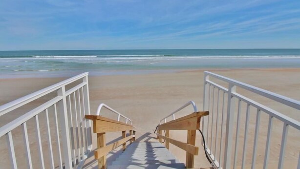 A wooden staircase leading to a beach with white railings. - Ocean Club North C208 (New Smyrna Beach)