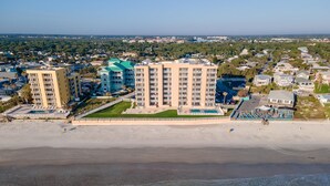 A beachfront hotel with multiple buildings, a swimming pool, and a beach. - Oceania Plaza 502 (New Smyrna Beach)