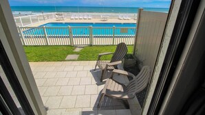 Un balcon avec vue sur une piscine et une plage.