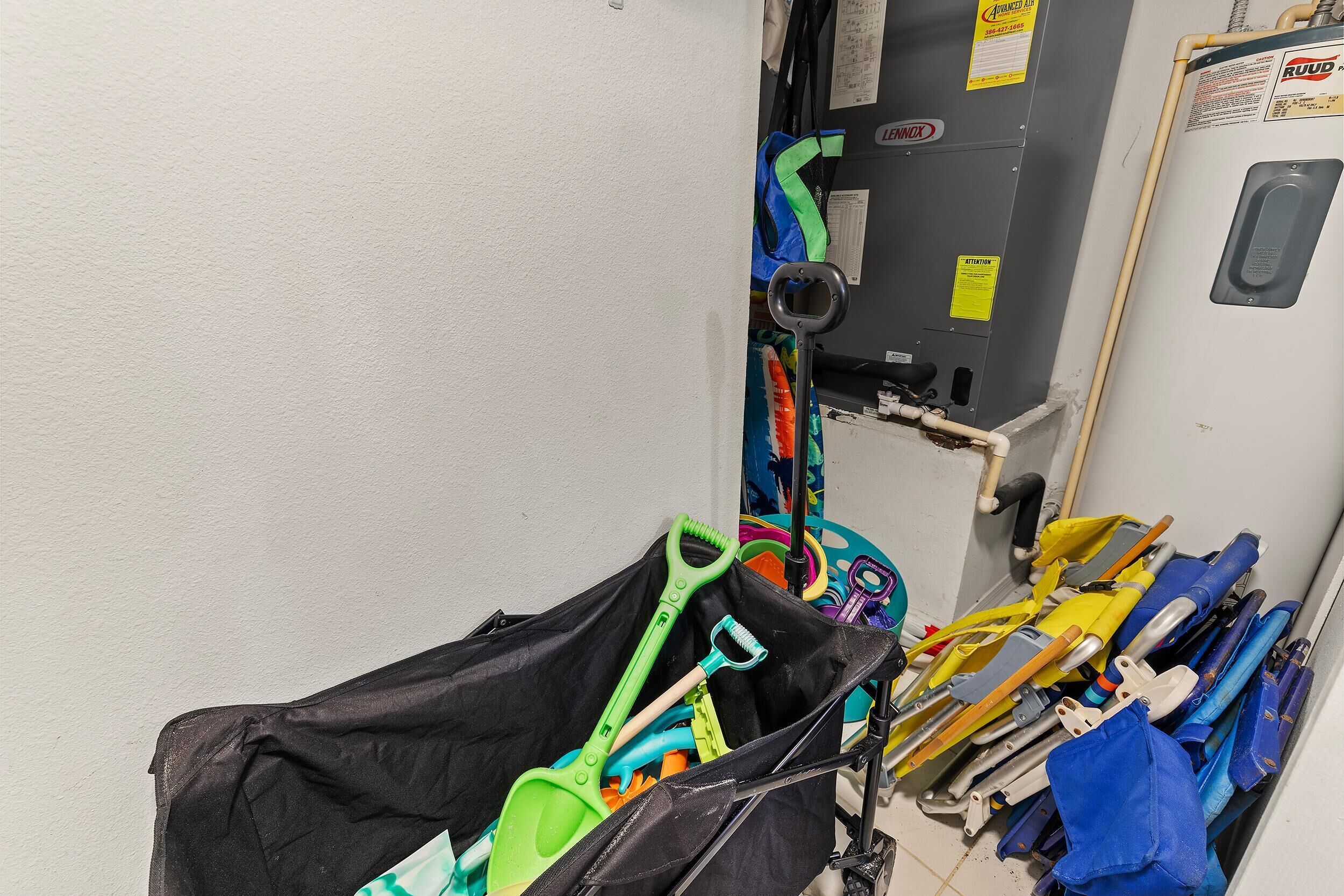 A storage area with cleaning equipment and a water heater.