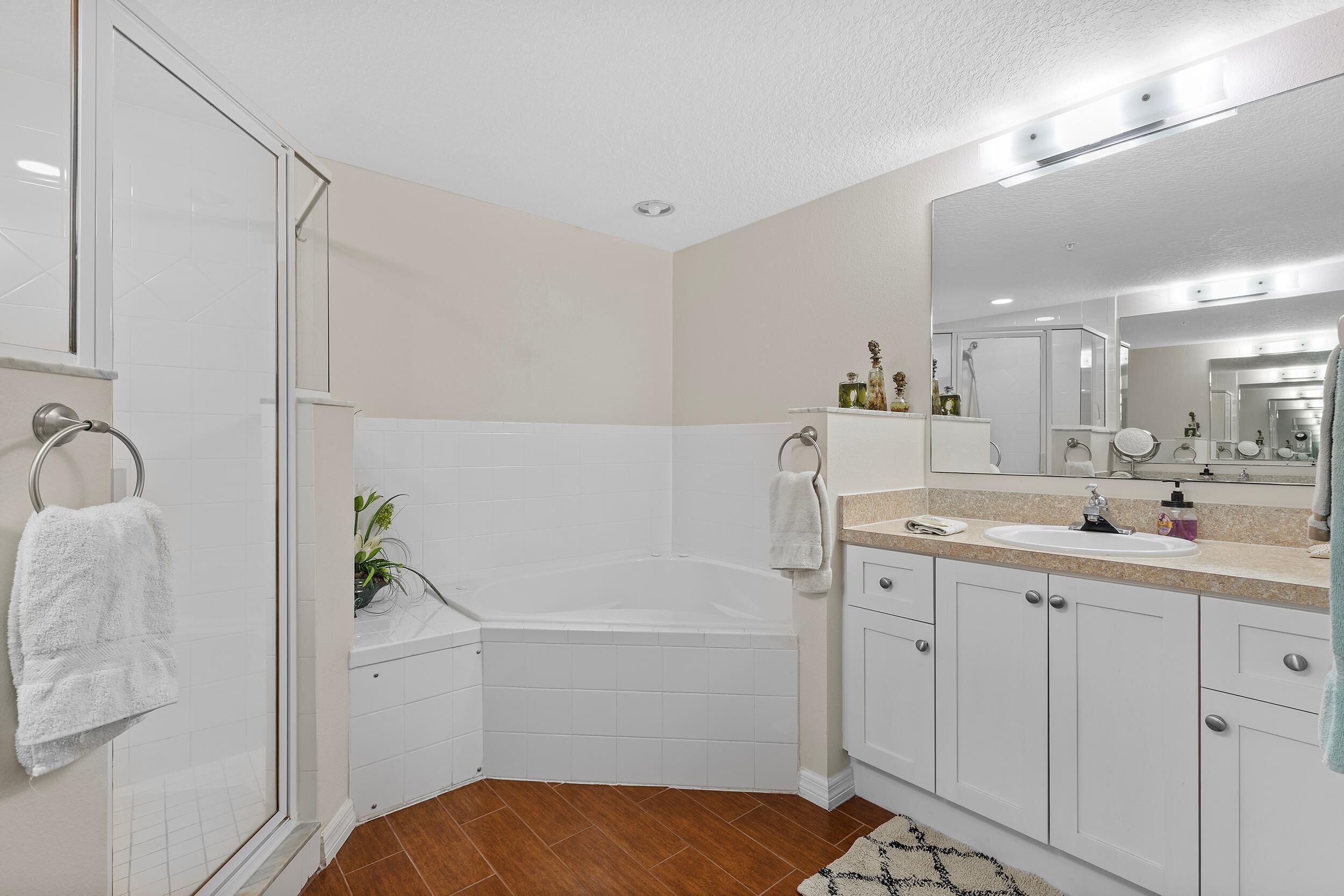 Une salle de bain moderne dotée d’une douche à parois de verre, d’une baignoire sur pieds et d’un meuble-lavabo avec miroir.