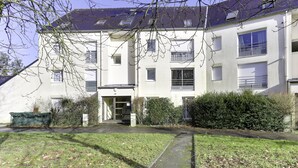Un edificio residenziale a più piani con tetto piatto, ampie finestre e un ingresso principale.