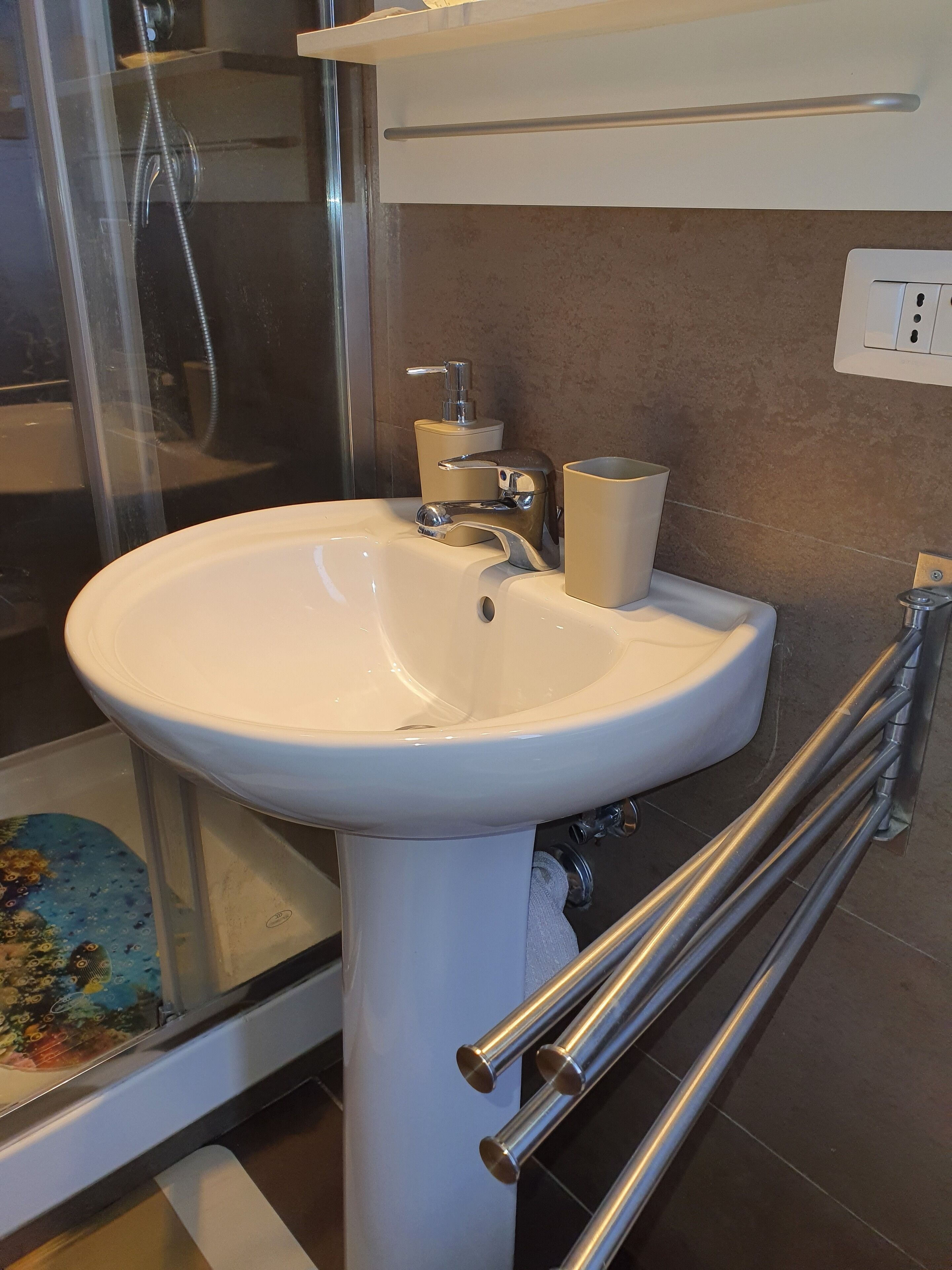 A bathroom with a white sink, a glass shower enclosure, and a toilet.