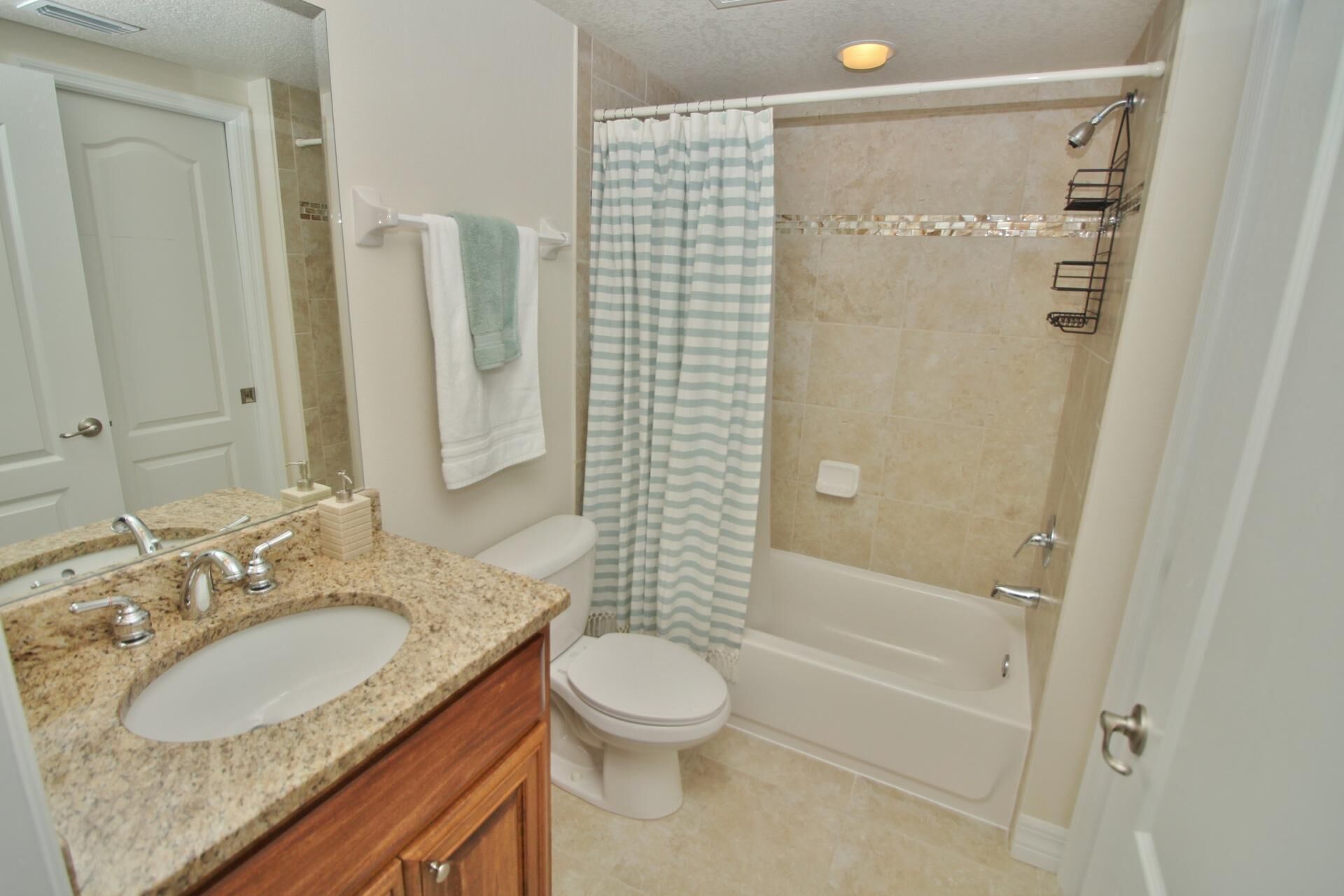 A bathroom with a double sink, toilet, and bathtub.