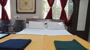 A hotel room with a bed, two chairs, a desk, and a window with red curtains. - B type Cottage (Koroli)