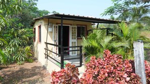 A small, single-story building with a tiled roof and a balcony. - B type Cottage (Koroli)