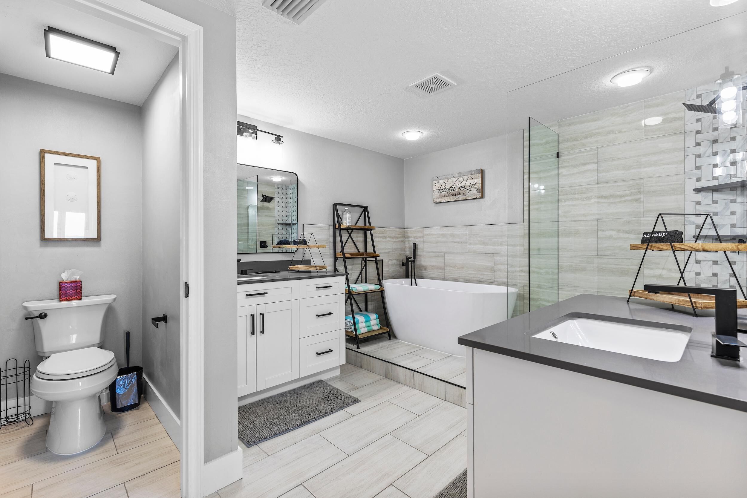 A modern bathroom with a toilet, sink, and bathtub.