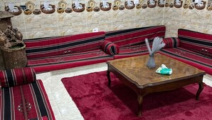 A living room with a sofa set, a coffee table, and a red rug. - PETRA BALCONY APARTMENT (Wadi Musa)