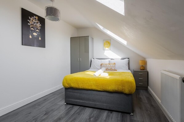 A bedroom with a bed, a wardrobe, a radiator, and a skylight. - Pemberton House By Smart Corporate Stays (Liverpool)