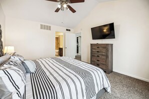 A bedroom with a bed, a dresser, a television, and a ceiling fan. - i655 - Apt|Yard|9mi to Fair Park|Sleeps 4 (Irving)