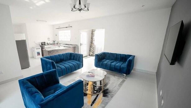Un salon moderne comprenant un canapé, une table basse et un téléviseur fixé au mur.