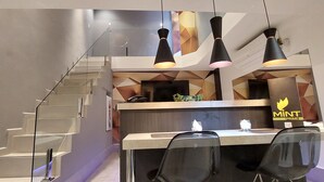 A modern kitchen with a central island, a staircase, and pendant lighting.