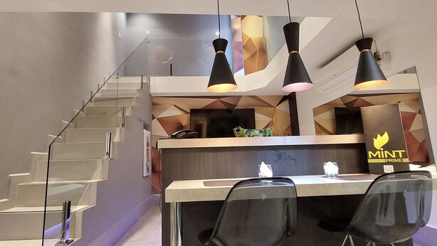 Une cuisine moderne dotée d’un îlot central, d’un escalier et de luminaires suspendus.