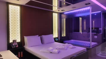 Una moderna camera d'hotel con un ampio letto, cabina doccia in vetro e pannelli decorativi a parete.