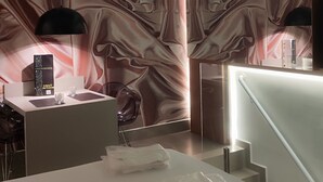A modern hotel room with a marble-patterned wall, a white reception desk, and a staircase.