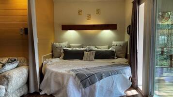 Ein gemütliches Schlafzimmer mit einem Bett, einer Couch und einem großen Fenster.