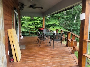 Enjoy dining and socializing on this covered deck surrounded by lush greenery.