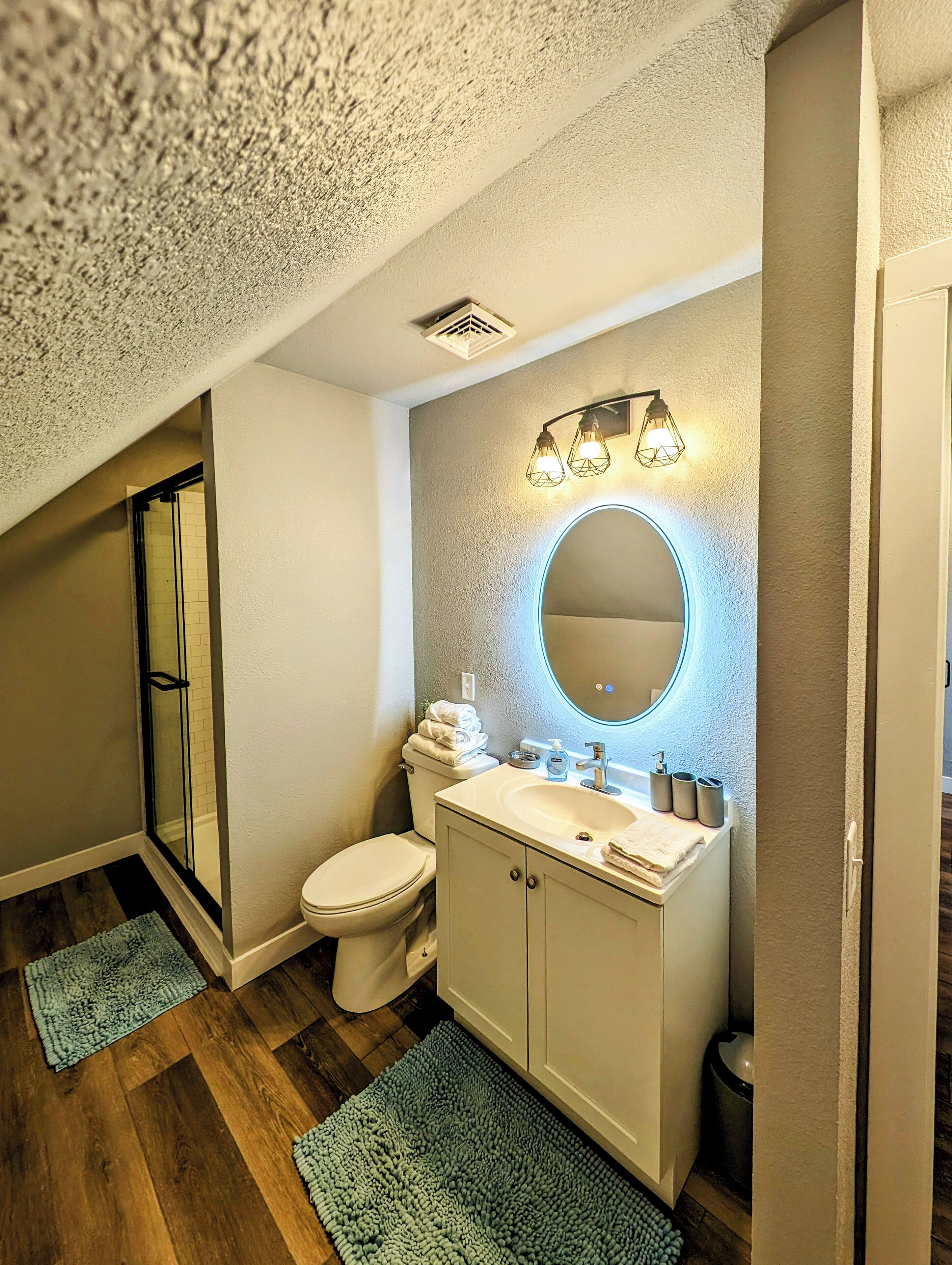 A bathroom with a toilet, sink, and shower.