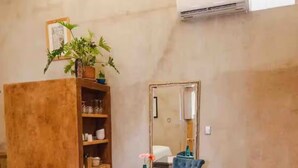 A dining area with a table, chairs, a mirror, and a potted plant.