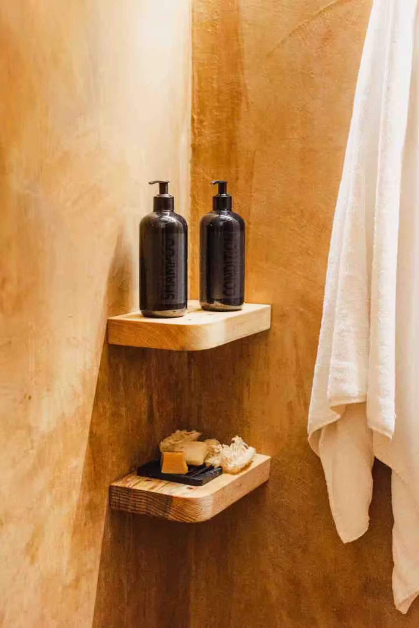 A bathroom with wooden shelves holding toiletries and a towel.