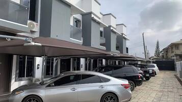 A modern residential building with a covered parking area.