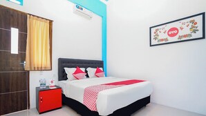 A hotel room with a bed, a red nightstand, a blue accent wall, and a framed picture on the wall. - Hotel O Mojoanyar Near Terminal Bis Mojokerto (Mojokerto)