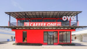 A red building with a sign that reads "CAFFEE ONE". - Hotel O Mojoanyar Near Terminal Bis Mojokerto (Mojokerto)