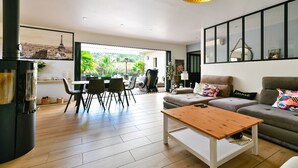 A modern living room with a sofa, coffee table, and dining area. - AIR-CONDITIONED VILLA WITH POOL IN PORTICCIO (Grosseto-Prugna)