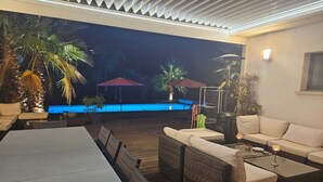 An outdoor patio with a pool, wicker furniture, and a table. - AIR-CONDITIONED VILLA WITH POOL IN PORTICCIO (Grosseto-Prugna)