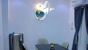 A dining area with a table, chairs, and a refrigerator. - D.T Homes Luxury Apartment (Ibadan)