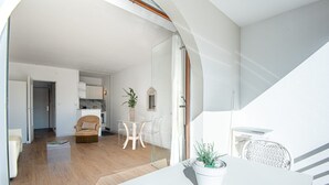A modern living space with a dining area, a kitchen, and a staircase. - ACCOMMODATION RESIDENCE CHIBERTA AND GOLF WITH SWIMMING POOL (Anglet)