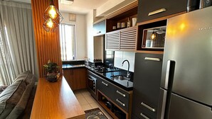 Eine moderne Küche mit einer Holzinsel, Edelstahlgeräten und einer schwarzen Spritzschutzwand.