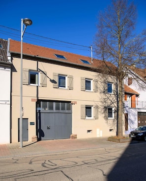 A building with a garage door, multiple windows, and a street lamp.