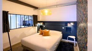 Una habitación de hotel moderna con una cama, una mesita auxiliar, una ventana con cortinas, una lámpara de techo y una pared con diseño.