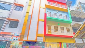 Un edificio de varios pisos con balcones y un cartel anunciando servicios de hotel.