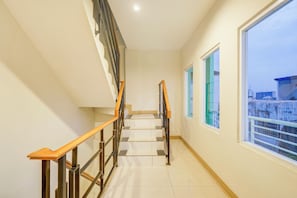 A staircase with wooden handrails and metal balusters, leading to an upper floor. - Hotel O Mangga Besar Near Mangga Besar Station Formerly Warna Warni Residence (Jakarta)