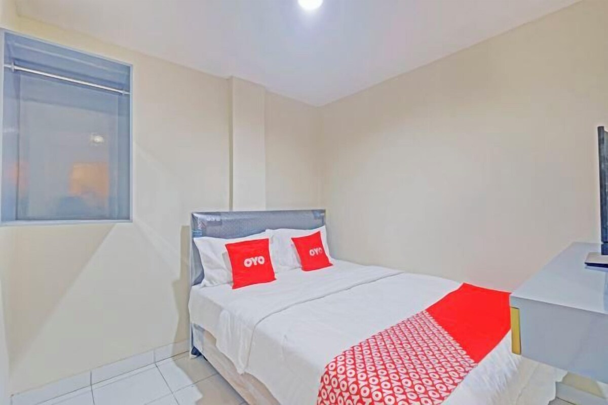 Une chambre à coucher avec un lit, une fenêtre et une table de chevet.