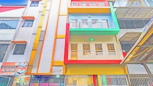 Un edificio de varios pisos con balcones y un letrero que indica un precio de Rp 90.000.