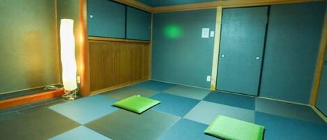 Una habitación con esteras de tatami, puertas correderas y una lámpara de techo.