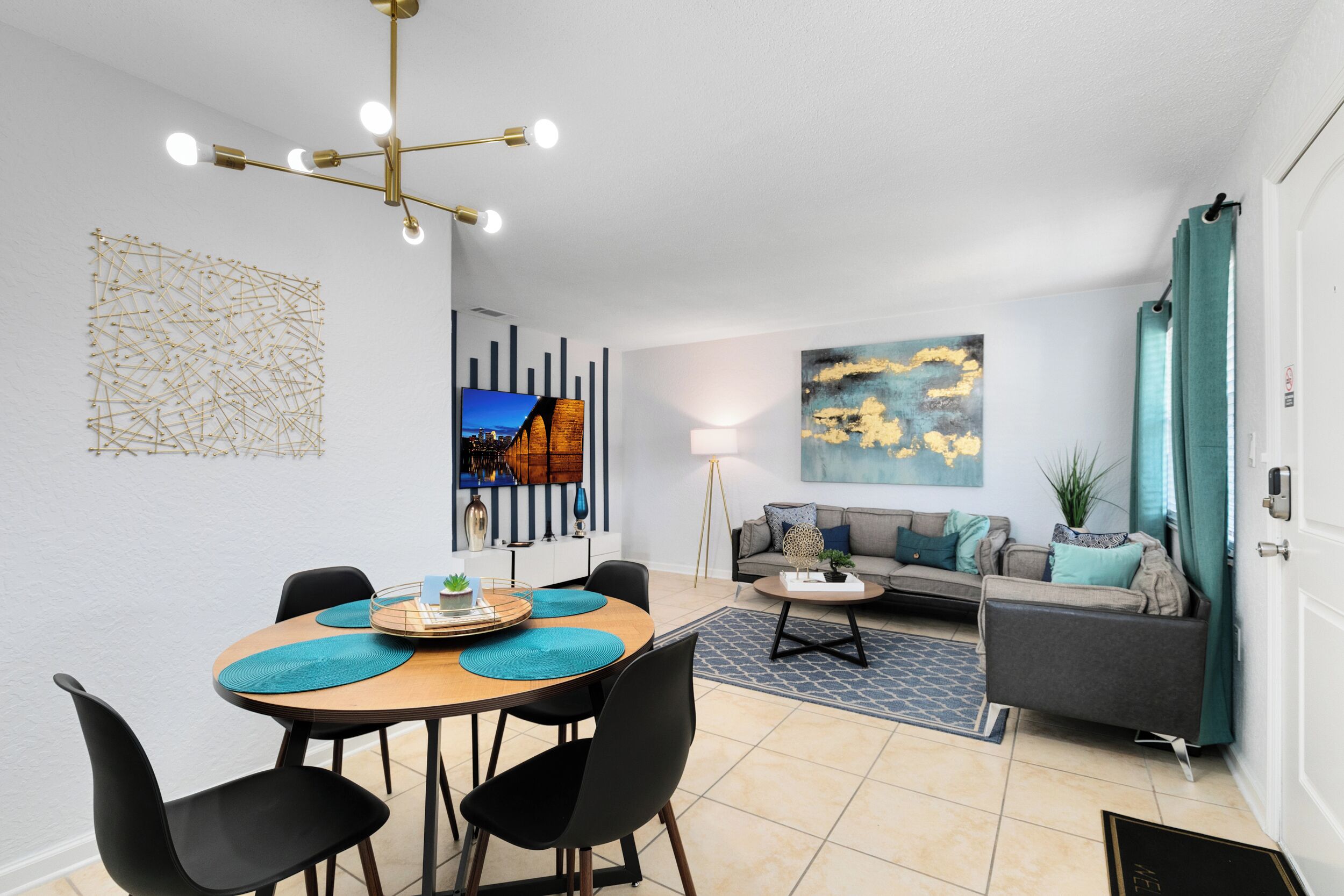 Una sala de estar moderna con comedor, que presenta una araña, obras de arte y un sofá con vistas.