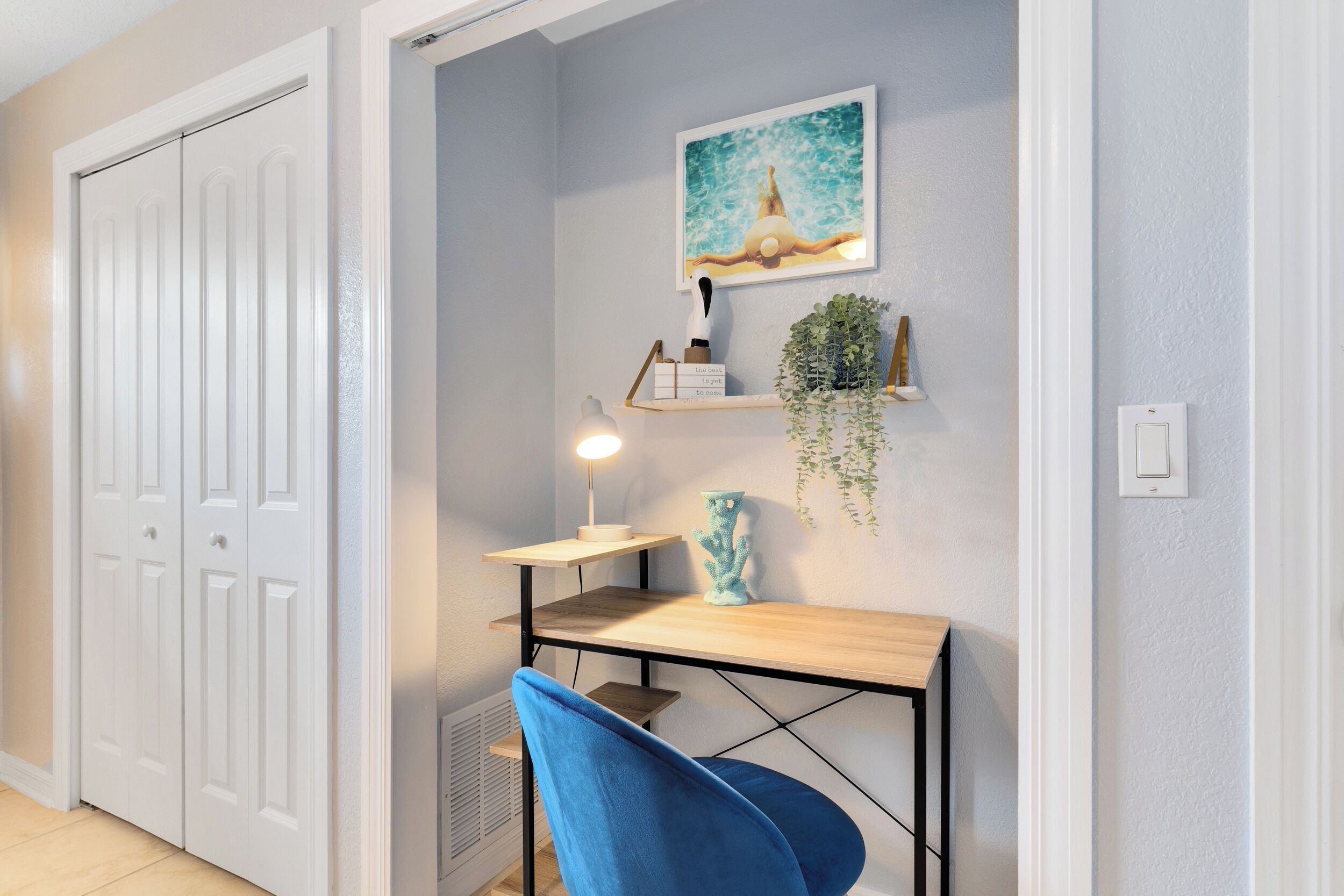 A room with a desk, chair, and a white door.