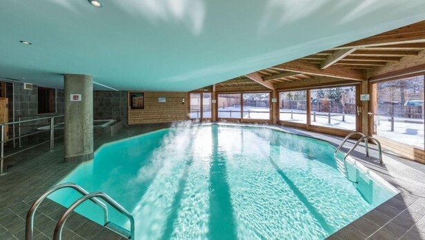 An indoor swimming pool with clear water, wooden beams on the ceiling, and large windows. - 300m from ski slopes, swimming pool, parking, tv, ski locker, 50m², Abriès (Abriès)