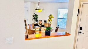 A dining area with a wooden table, chairs, and potted plants. - Tucson two story 4BR  2.5BA house close to airport & major attractions Sleeps 8 (Tucson)