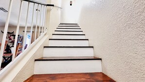 A staircase with white walls and wooden steps leading to a landing. - Tucson two story 4BR  2.5BA house close to airport & major attractions Sleeps 8 (Tucson)